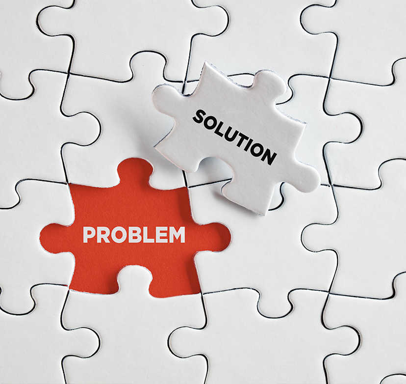 A white puzzle with one missing piece labeled PROBLEM in red, while a separate puzzle piece labeled SOLUTION is about to be placed in the empty spot.